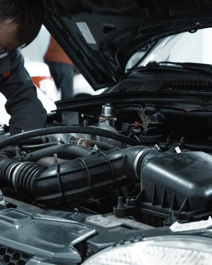 Open engine bay of a car under a workshop light