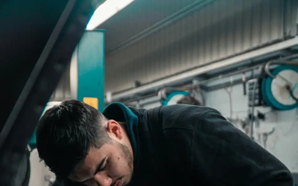 A mechanic working on a car engine in a workshop
