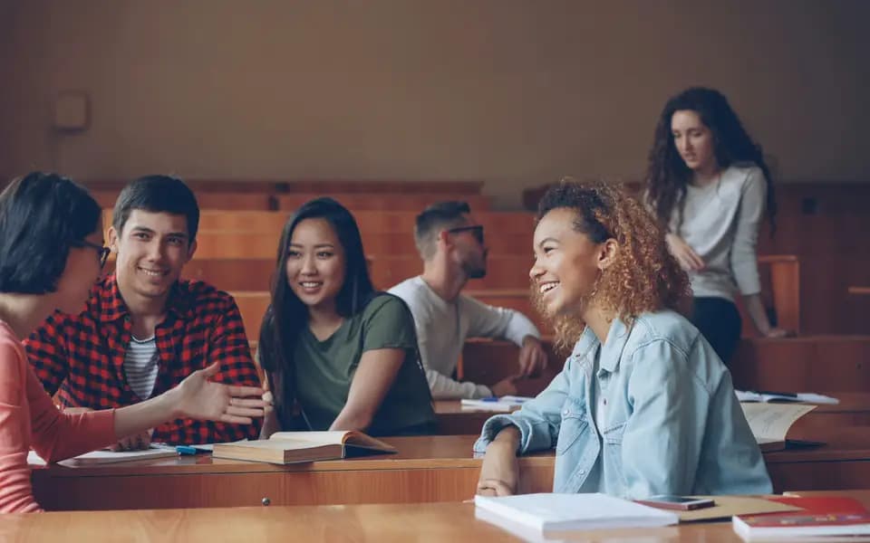 Students smiling and talking together in a lecture hall