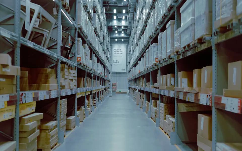 A long warehouse aisle with tall shelving full of boxes