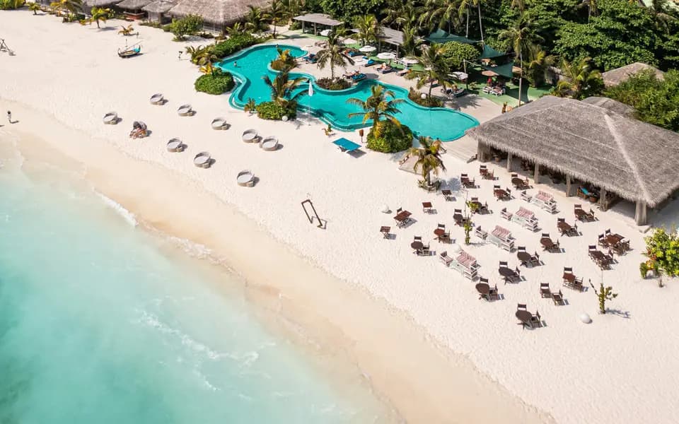 Aerial view of a beach resort with a pool and palm trees