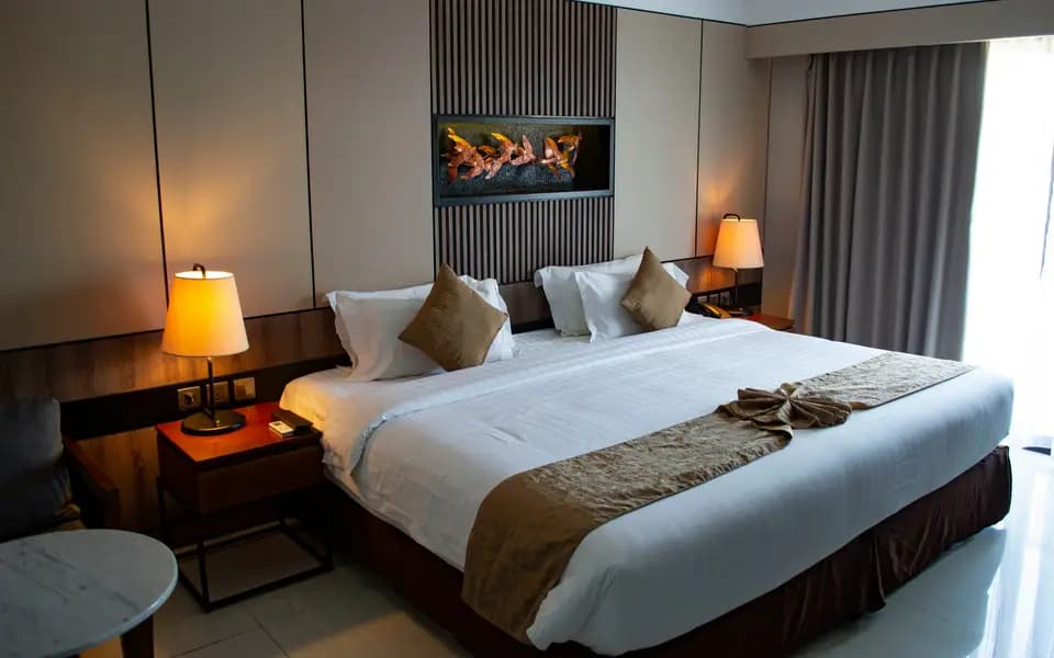Hotel bedroom with a made bed and bedside lamps