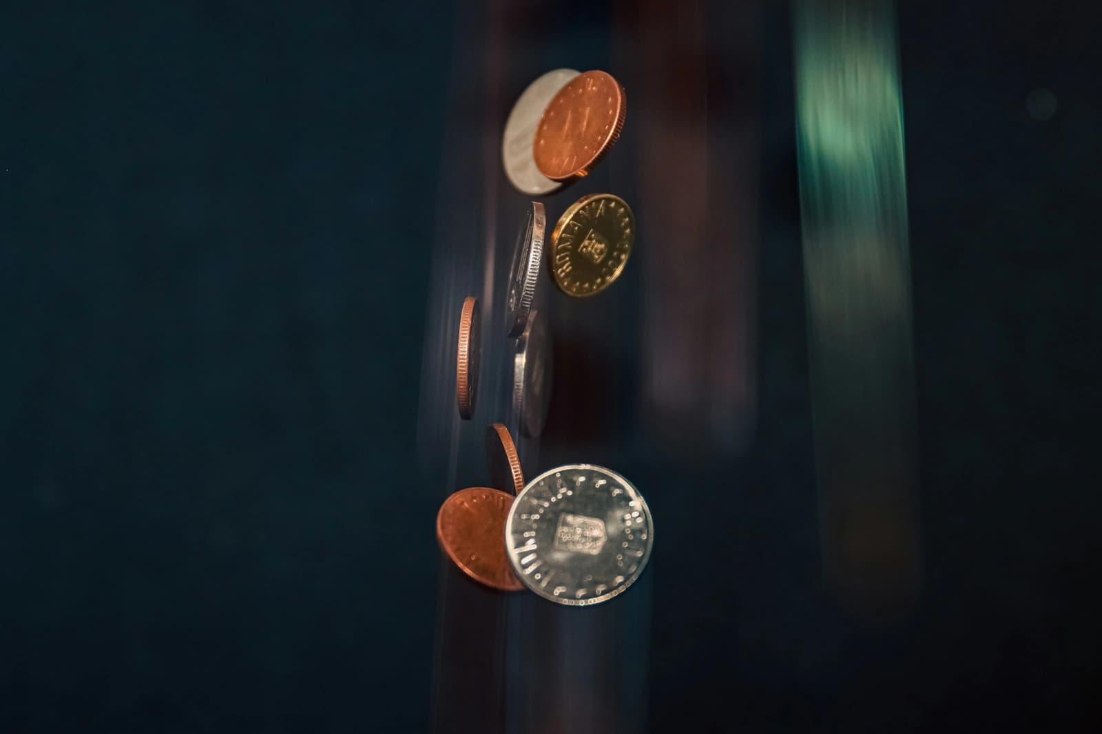 Coins falling past a dark background