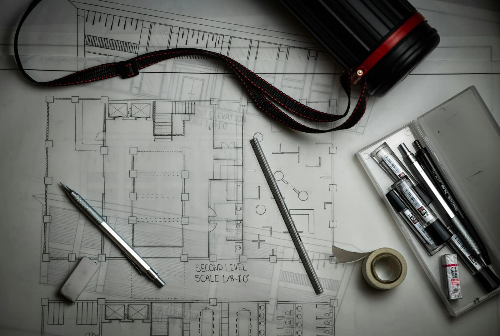 Architectural plans with drafting pencils and a ruler